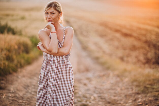 Young beautiful woman on the sunset in field