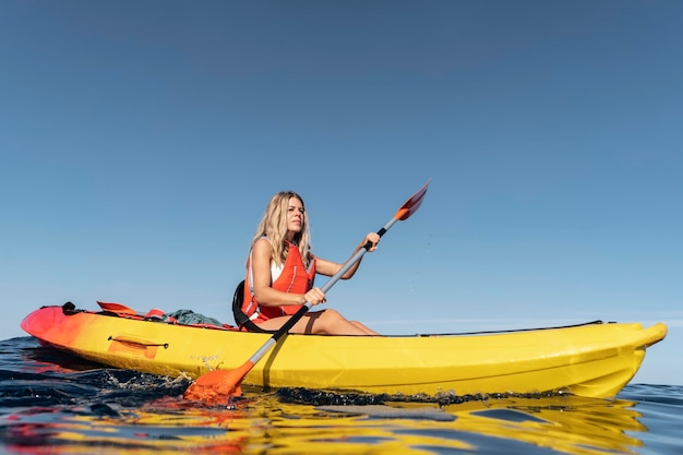 Free photo young beautiful woman traveling by canoe