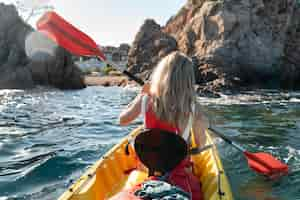 Free photo young beautiful woman traveling by canoe