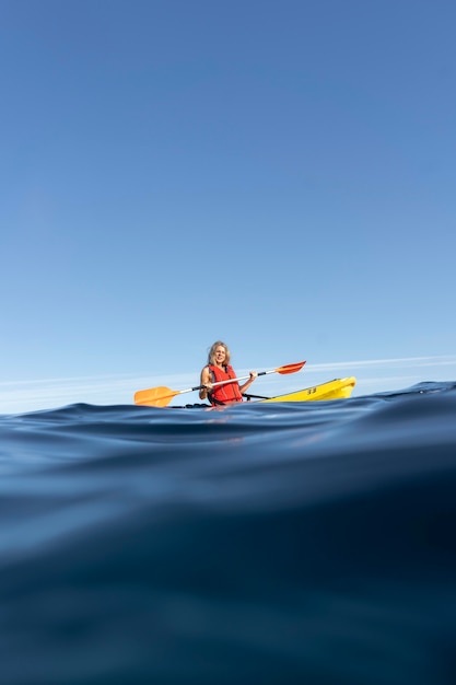 Free photo young beautiful woman traveling by canoe