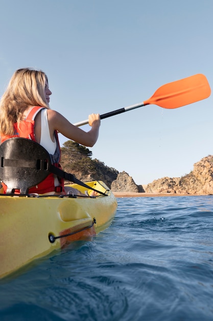 Free photo young beautiful woman traveling by canoe