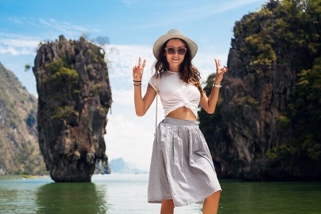 Young beautiful woman traveling in thailand, summer vacation, casual style, sunglasses, hat, cotton skirt, t-shirt, smiling, happy, adventures