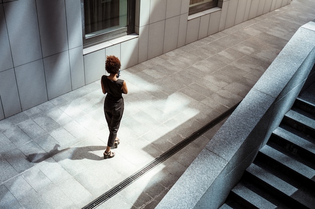 Young beautiful woman walking down city