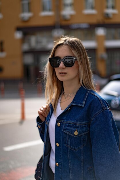 Young beautiful woman walks around the city in Europe, street photo, female posing in the city center