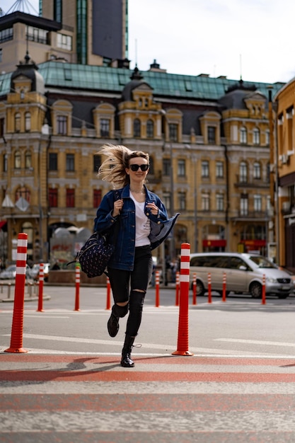 Young beautiful woman walks around the city in Europe, street photo, female posing in the city center