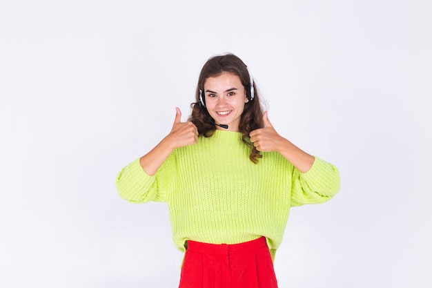 Young beautiful woman with freckles light makeup in sweater on white wall with headphones helpline worker call centre manager happy smile