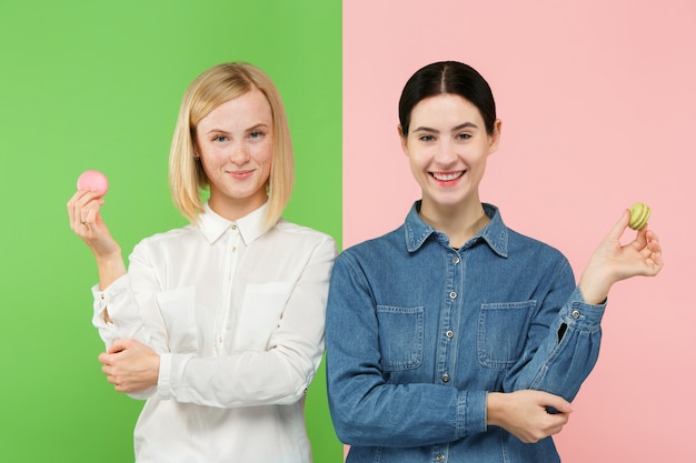 Free Photo young beautiful women holding macaroons pastry in her hands