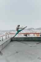 Free photo young black man dancing on the rooftop of a building