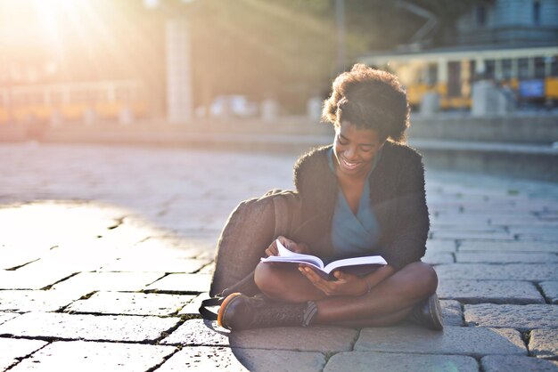 young black woman on the street reads a book