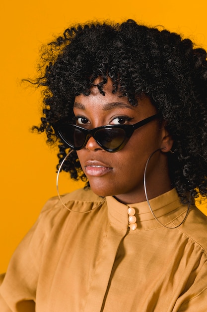 Free photo young black woman wearing sunglasses looking at camera