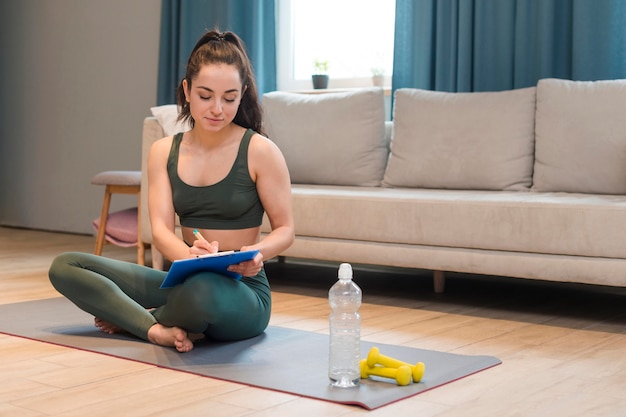 Young blogger sitting and writing on clipboard