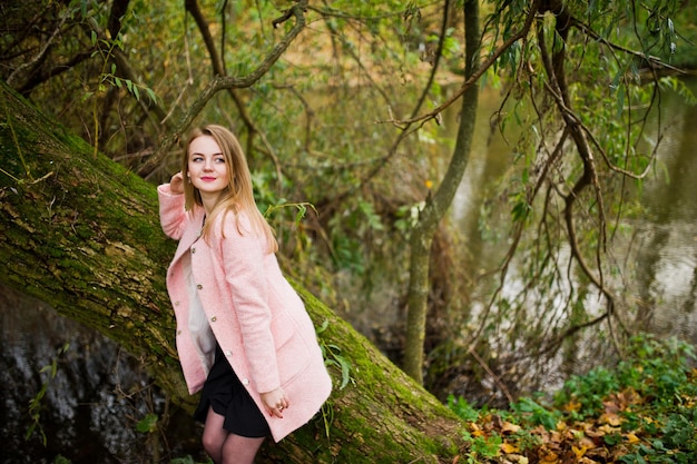 Free Photo young blonde girl at pink coat posed on autumn park