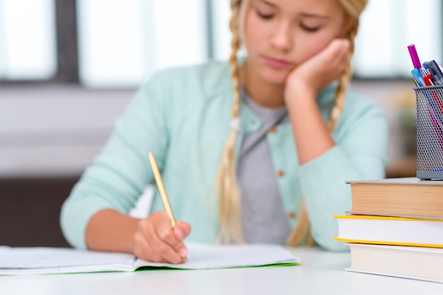 Young blonde student writing indoors