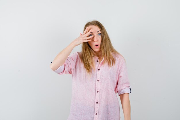 Young blonde woman in a casual pink shirt