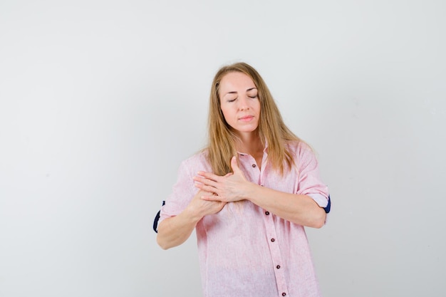 Young blonde woman in a casual pink shirt