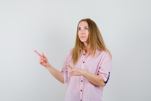 Young blonde woman in a casual pink shirt