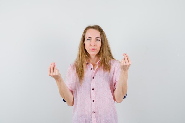 Young blonde woman in a casual pink shirt