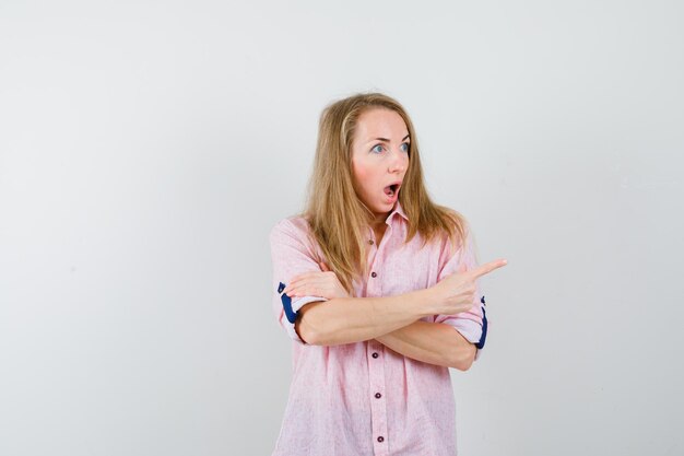 Young blonde woman in a casual pink shirt