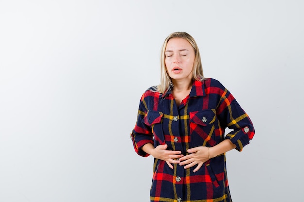 Free photo young blonde woman having a stomachache