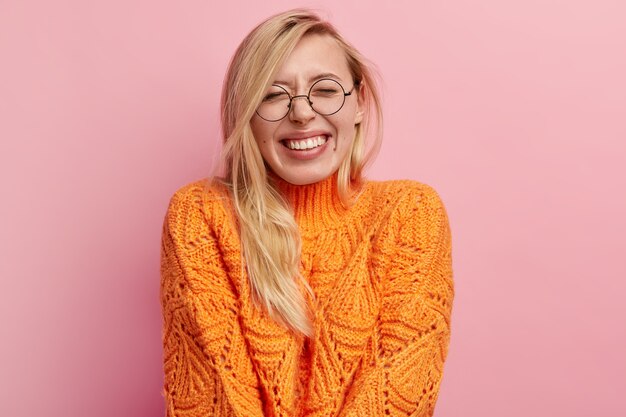 Young blonde woman in orange sweater