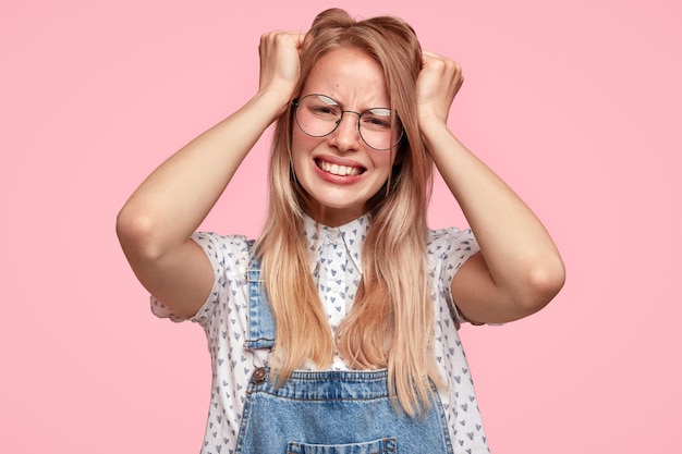 Free photo young blonde woman in overalls