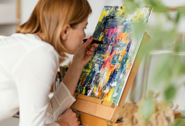 Young blonde woman painting with acrylics