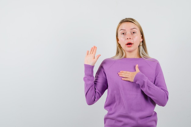 Free photo young blonde woman in a purple sweater