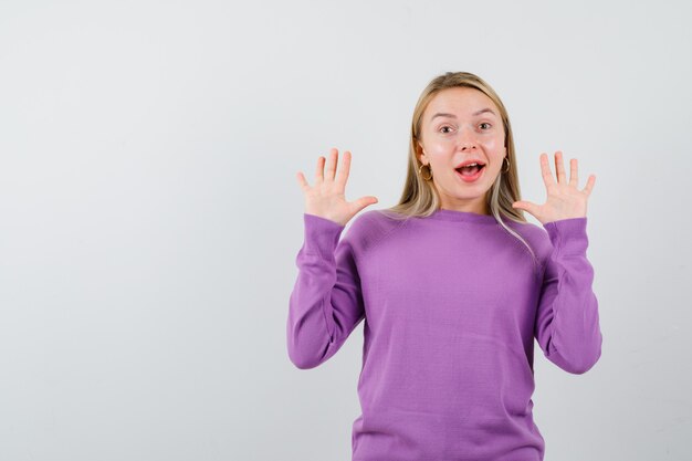 Young blonde woman in a purple sweater