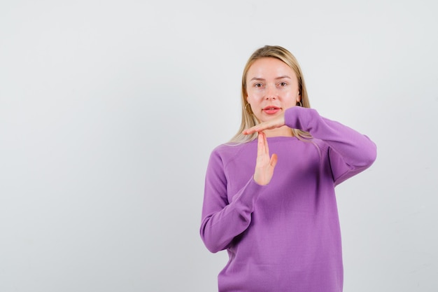 Young blonde woman in a purple sweater