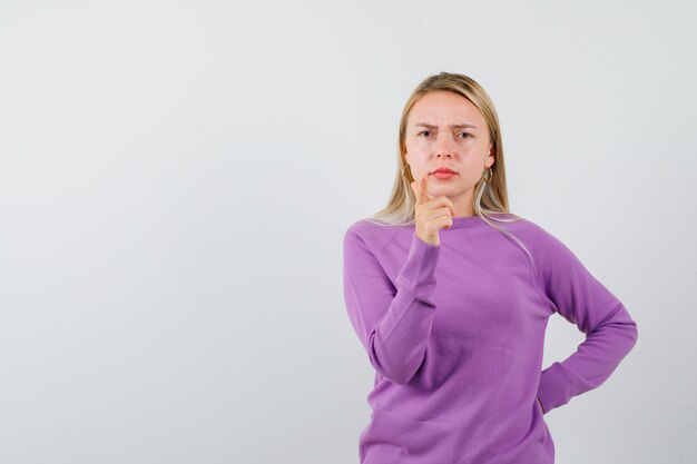 Young blonde woman in a purple sweater