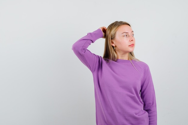 Free photo young blonde woman in a purple sweater