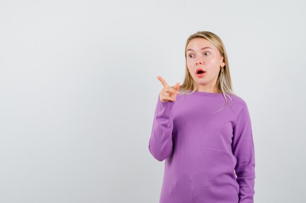 Young blonde woman in a purple sweater