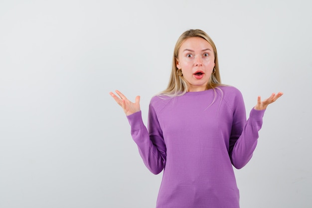 Young blonde woman in a purple sweater