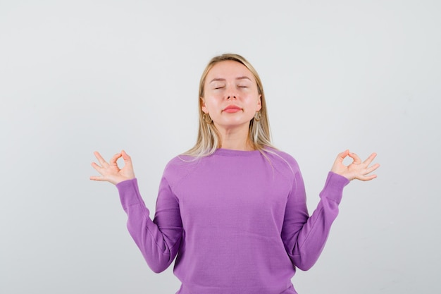 Young blonde woman in a purple sweater