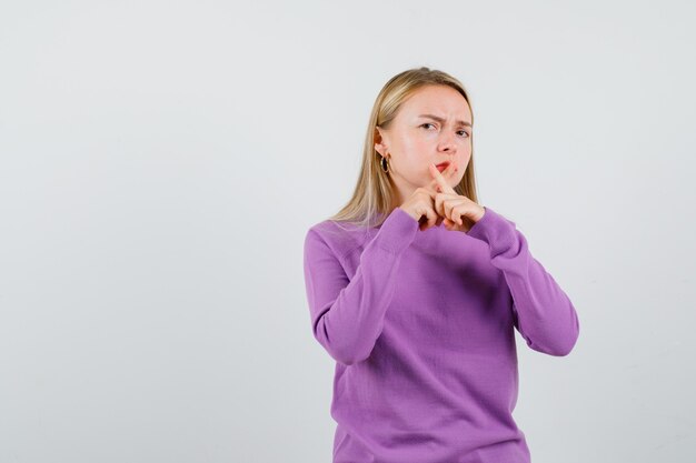 Young blonde woman in a purple sweater