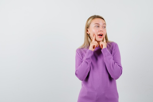 Young blonde woman in a purple sweater