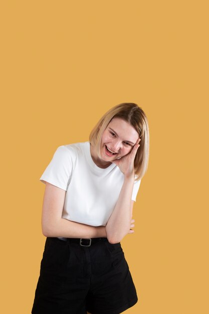 Young blonde woman smiling isolated on yellow