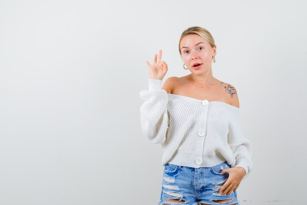 Young blonde woman in a white cardigan