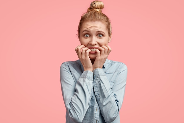 Free photo young blonde woman with hair in bun and wearing denim jacket