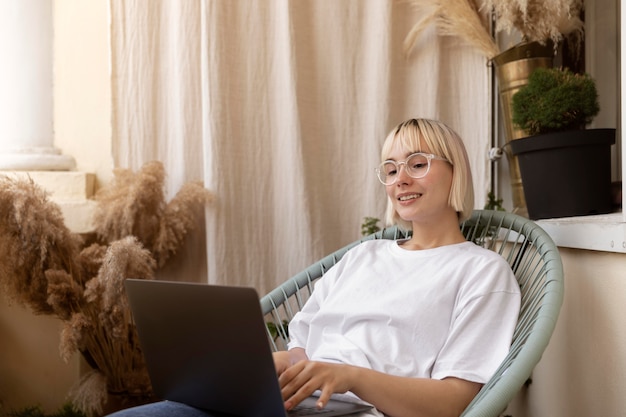 Free photo young blonde woman working from home in her chair