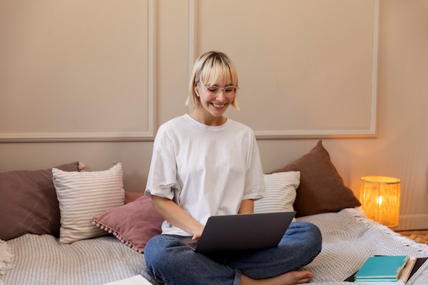 Young blonde woman working from home on her laptop