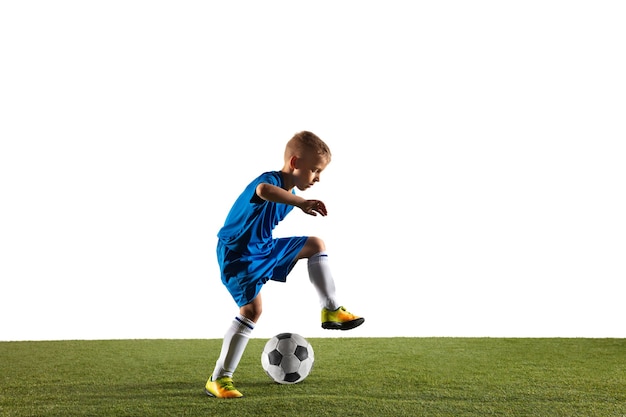 Young boy as a soccer or football player in sportwear making a feint or a kick with the ball for a goal on white  background.