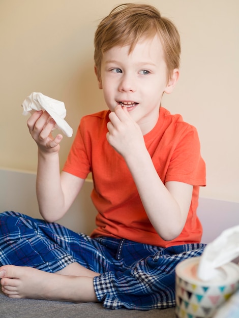 Free photo young boy blowing his nose