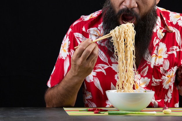 Free Photo young boy is enjoy eatting instant noodle at home.