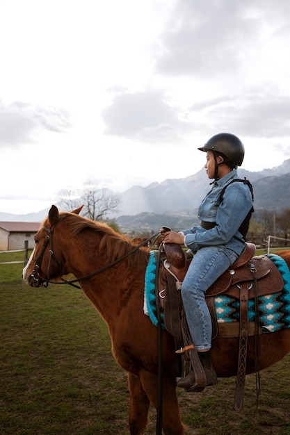 Free photo young boy learning how to ride horse