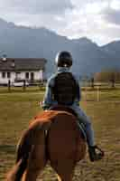 Free photo young boy learning how to ride horse