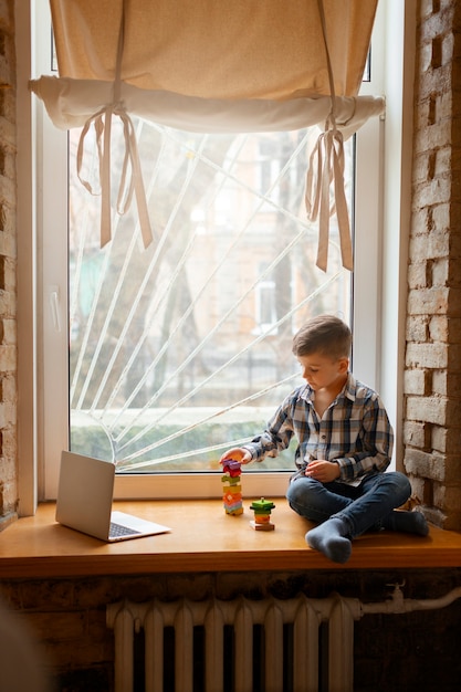 Free photo young boy playing indoors with eco toys