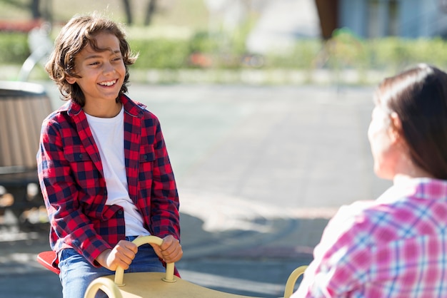 Young boy playing with mother at the park