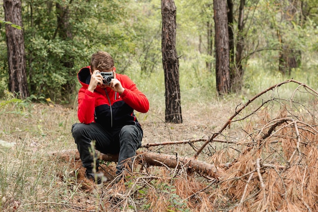 Free Photo young boy taking pictures in forest with copy-space