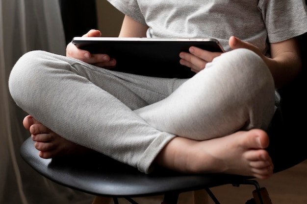 Young boy using tablet while sitting on chair